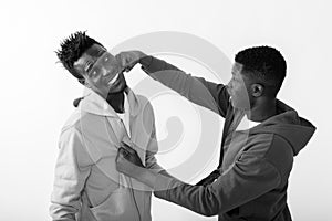 Young African man punching happy slim black African man smiling