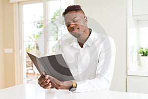 Young african man reading a book, studying for univeristy photo