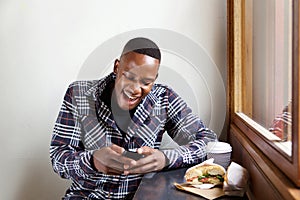 Young african man reading a funny text message