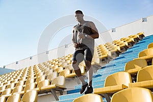 Young african man runner in sport clothes running downstairs a