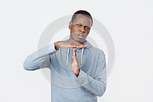 Young african man showing time out hands gesture .