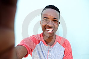 Young african man smiling and taking selfie