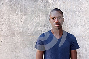 Young african man standing agaisnt gray wall