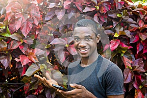 young african man using his mobile phone looking looking excited