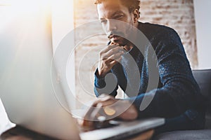 Young African man using laptop while sitting at his modern coworking place.Concept of business people full concentration