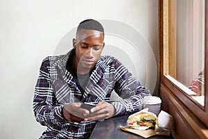 Young african man using mobile phone at a cafe