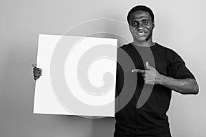 Young African man wearing black shirt against gray background