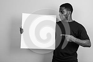 Young African man wearing black shirt against gray background