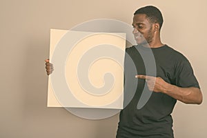 Young African man wearing black shirt against gray background