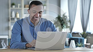 Young African Man Working On Laptop in Office