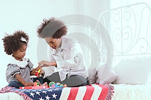 Young African mother raises her children and plays with them lovingly at home