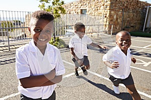 Young African schoolboys running in school playground photo