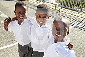 Young African schoolboys smiling to camera in a playground