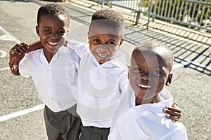 Young African schoolboys smiling to camera in a playground photo