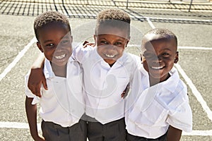 Young African schoolboys smiling to camera in a playground photo