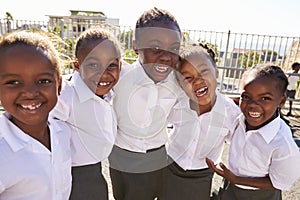 Young African schoolgirls in playground smiling to camera