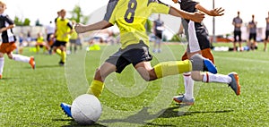 Young african soccer player running fast and kicking white football ball. Youth footballers compete in tournament match. Soccer photo