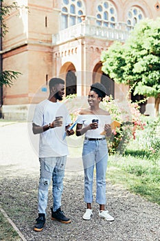 Young african two students drink coffee and disscuss in campus Uni