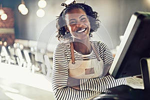 Young African waitress laughing while working in a trendy restau