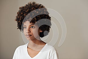 Young African woman with an afro against a gray background