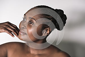 Young African woman with a beautiful complexion touching her chin