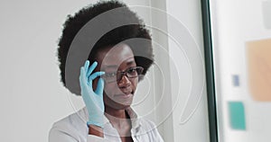 Young African Woman Doctor Or Nurse Standing In Medical Suit At Clinic And Looking At Camera. Confident Doctor. Portrait