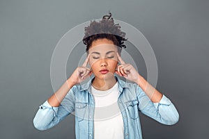 Young african woman on grey wall studio casual daily lifestyle relaxed