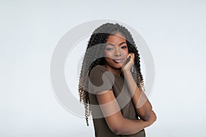 Young African woman with hand under chin and looking sideways with doubtful and skeptical expression, suspect and doubt
