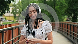 A young African woman in headphones dances cheerfully. Freedom, carefree youth