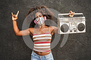 Young african woman listening music in boombox vintage stereo - Focus on face
