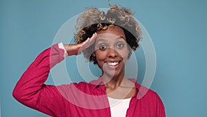 Young african woman looking at camera with salute and ready to do your order.