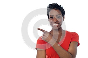 Young african woman pointing away