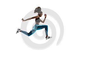 Young african woman running or jogging isolated on white studio background.