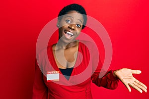 Young african woman with short hair wearing hello my name is sticker identification celebrating achievement with happy smile and