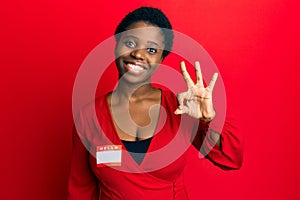 Young african woman with short hair wearing hello my name is sticker identification doing ok sign with fingers, smiling friendly
