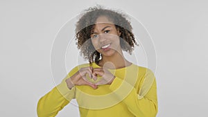 Young African Woman showing Heart Shape by Hands on White Background