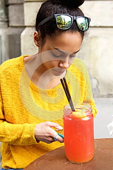 Young african woman sitting at a outdoor cafe