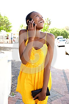 Young african woman in summer dress talking on cell phone