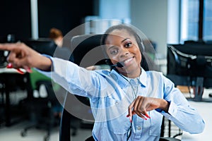 Young african woman talking to a client on a headset. Happy female call center employee.