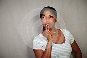 Young african woman thinking with hand on chin