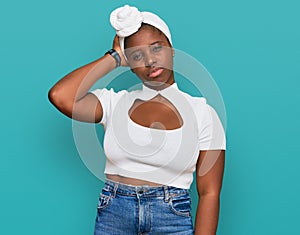 Young african woman with turban wearing hair turban over  background confuse and wondering about question