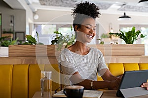 Young african woman using digital tablet at coffee shop