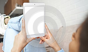 Young african woman using digital tablet looking at mock up white screen.