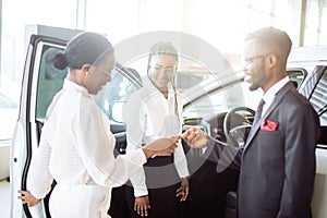 Young woman surprised by new car, gift for my beautiful wife photo