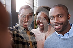 Young African work colleagues smiling together in an office