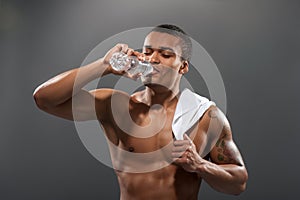 Young Africana sportsman drinking water after