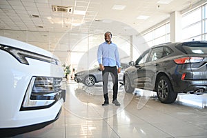 young africanamerican man came to see automobiles in dealership or cars showroom