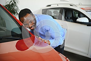 young africanamerican man came to see automobiles in dealership or cars showroom photo