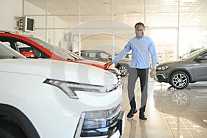 young africanamerican man came to see automobiles in dealership or cars showroom