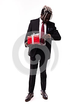 Young afro american businessman holding gift box and look at watch isolated on white background